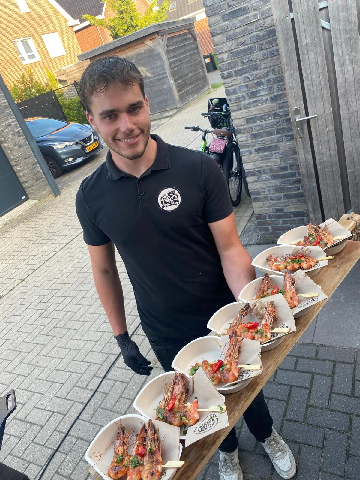 Medewerker van De Frietboerderij serveert gerechten op een evenement